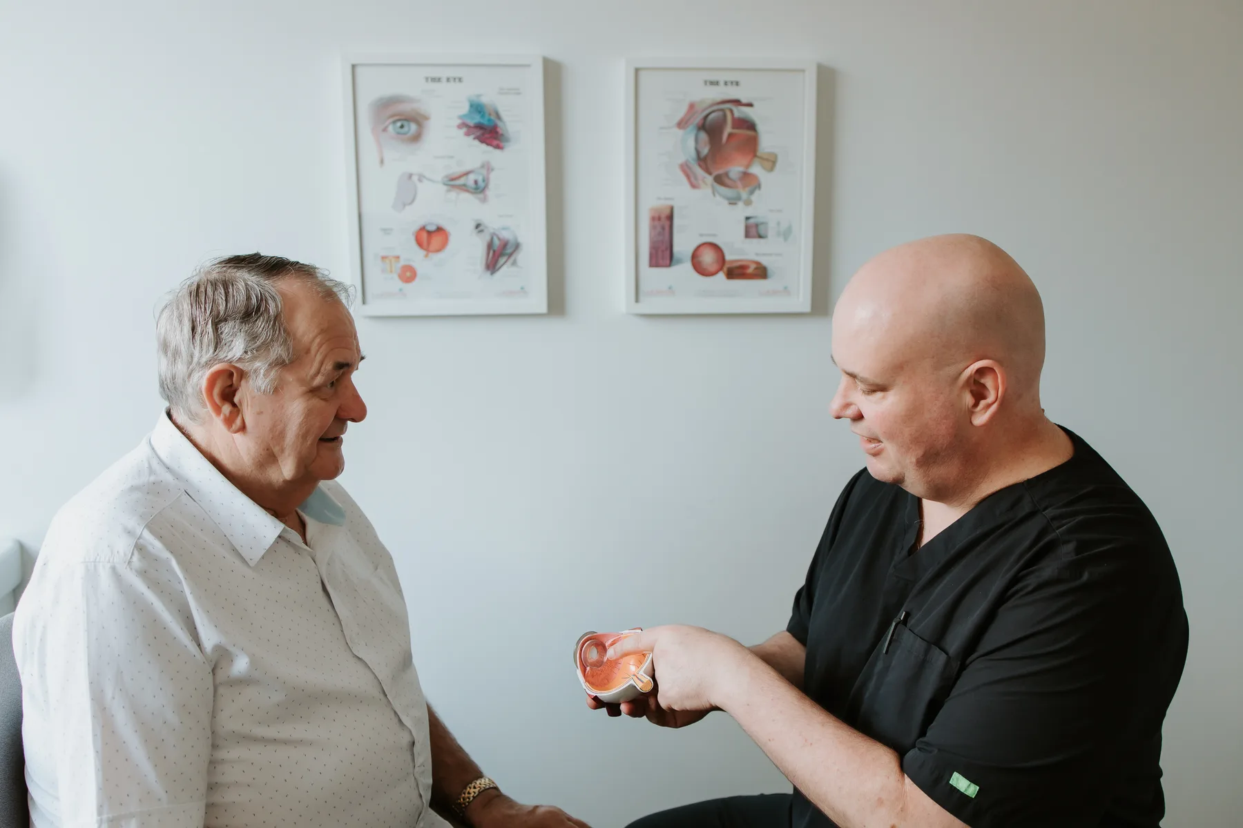 A/Prof Hunt using an eye model to explain cataract surgery to a patient