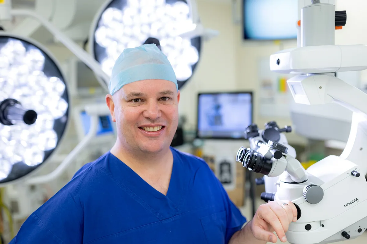 A/Prof Adrian Hunt in the operating theatre beside the surgical microscope