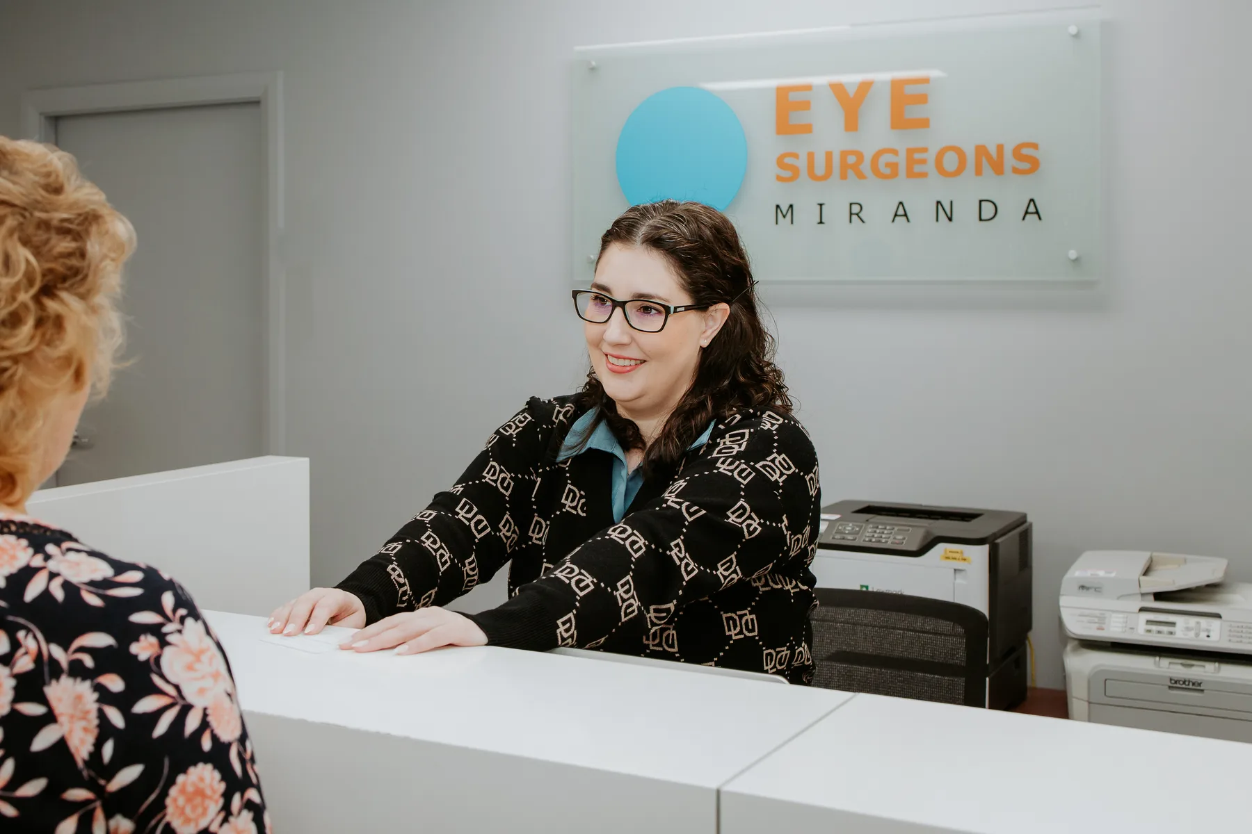 The reception desk at Eye Surgeons Miranda, beneath the practice sign