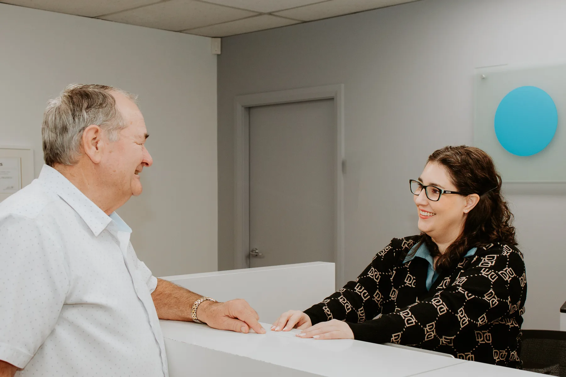 A patient with the reception team at Eye Surgeons Miranda